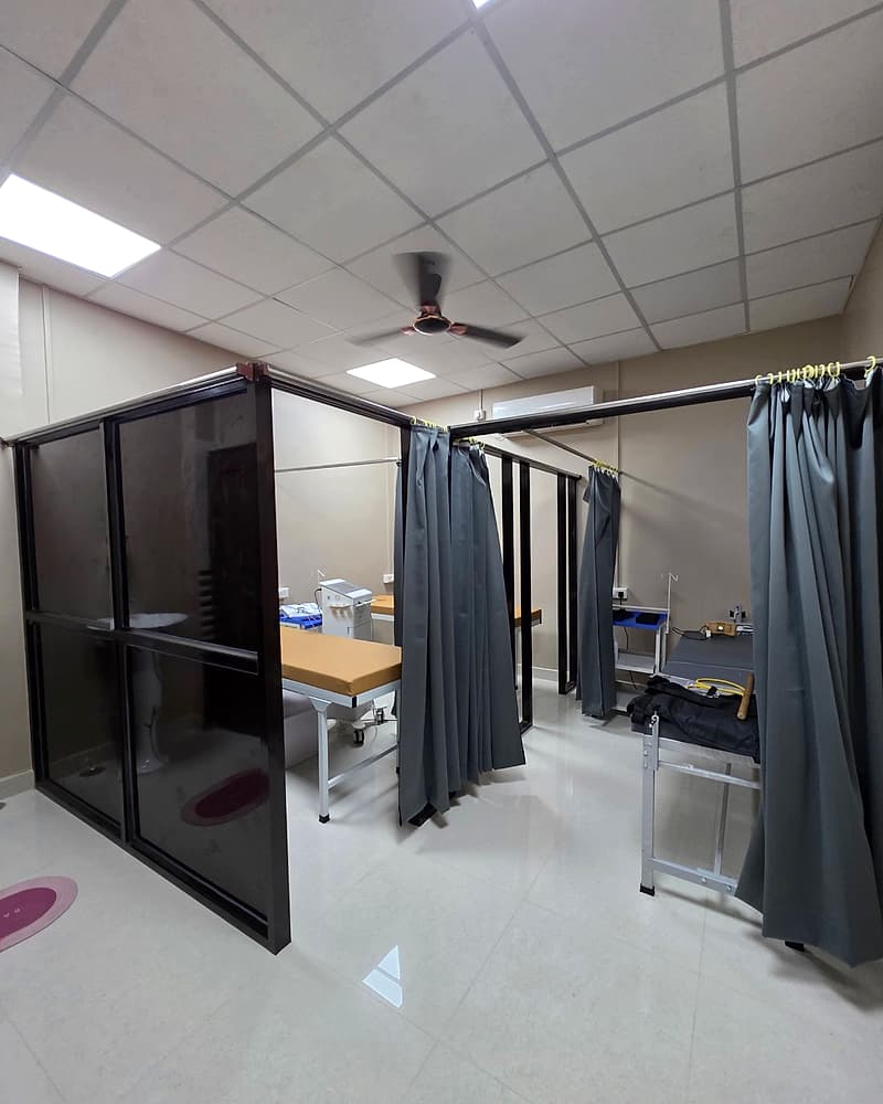 Private, curtained treatment bays with therapy tables and electrotherapy equipment